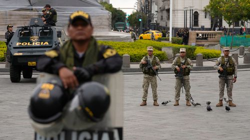 Des soldats et des policiers montent la garde à San Martin Plaza à Lima, Pérou