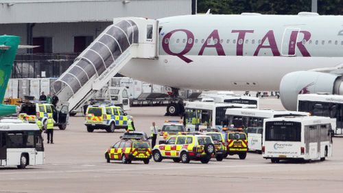 Police and emergency services surround the Qatar Airways plane that was subject to a bomb threat. (AAP)