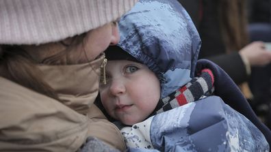 A woman holding a young child arrive at the border crossing in Medyka, Poland, Friday, March 4, 2022.