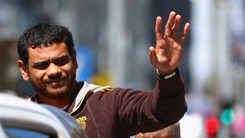 Cyril Rioli waves to the sea of Hawthorn fans who turned out for the AFL Grand Final parade. (Getty Images)