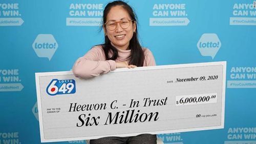 Heewon (Theresa) Choi holds up a giant cheque for $6 million (A$6.3 million) after winning the lottery.
