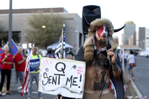 ADVANCE FOR PUBLICATION ON THURSDAY, SEPT. 9, AND THEREAFTER - FILE - Jacob Anthony Chansley, who also goes by the name Jake Angeli, a QAnon believer, speaks to a crowd of President Donald Trump supporters outside of the Maricopa County Recorder's Office where votes in the general election are being counted, in Phoenix, Nov. 5, 2020. Twenty years on, the skepticism and suspicion first revealed by 9/11 conspiracy theories has metastasized, spread by the internet and nurtured by pundits and politi