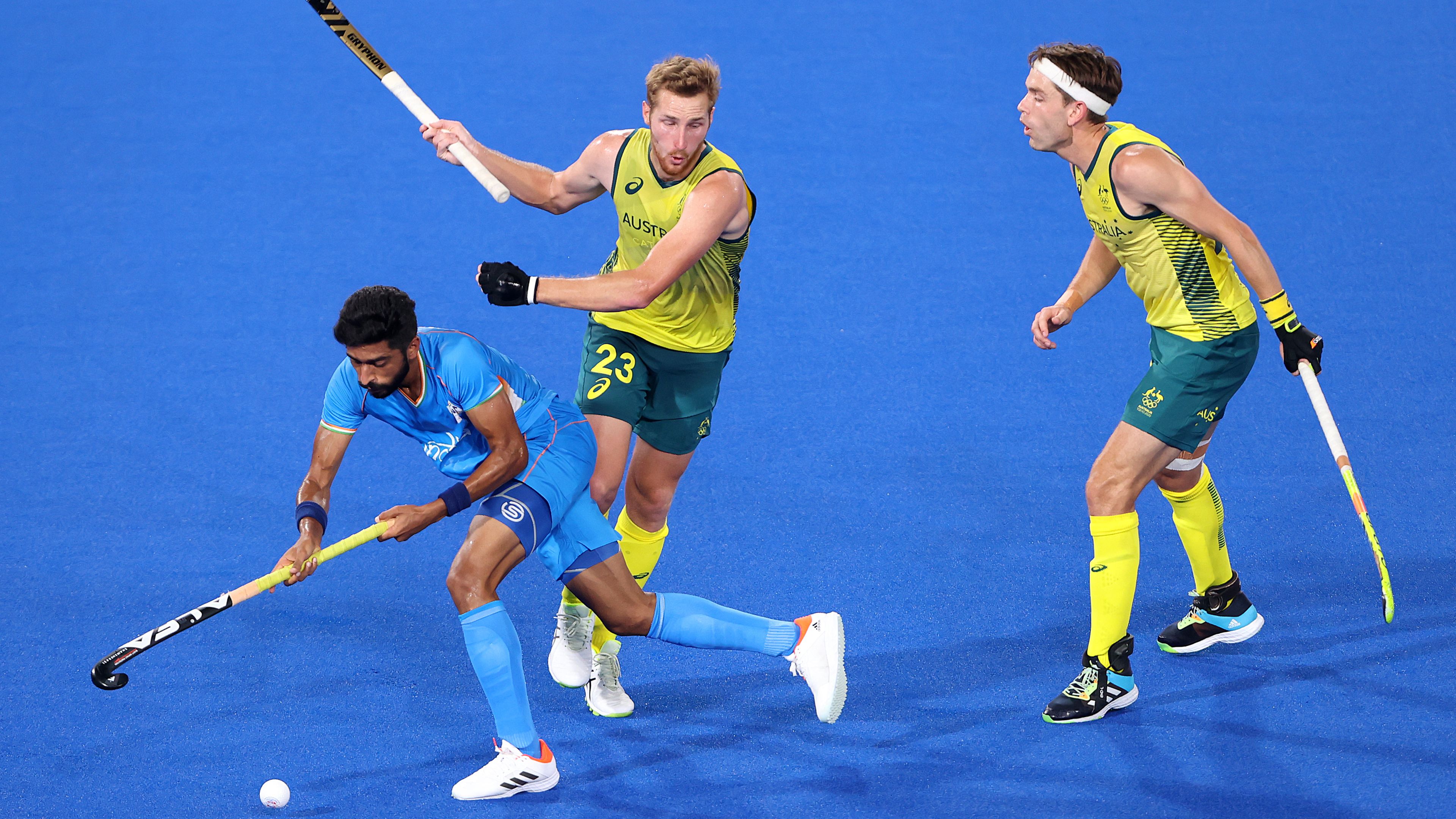 Australia and India tussle for possession in Tokyo.