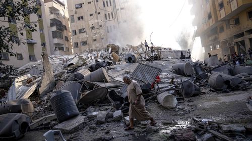 加沙城一栋建筑被以色列空袭轰炸后，巴勒斯坦人正在检查其废墟。