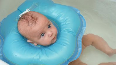 Baby in bath with baby neck float.
