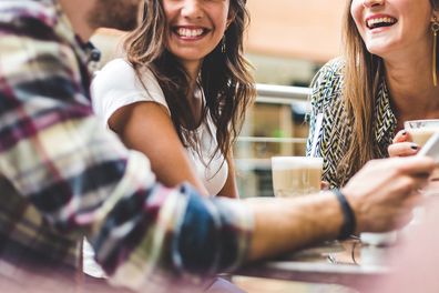 Two women and a man having coffee together in a cafe