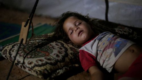 In this 2017 file photo, Saja Salih, 3, sleeps in her tent in the Hassan Sham camp for displaced people in Northern Iraq. Earlier that year, her family home in Mosul was destroyed by an air strike.