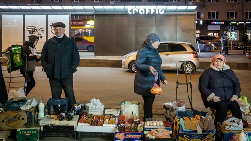 Vânzătorii ambulanți vând legume și alte produse locale pe trotuar din fața stației de metrou Lukyanivska din Kiev, Ucraina.