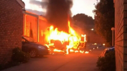 A car burst into flames before rolling into a group of units.