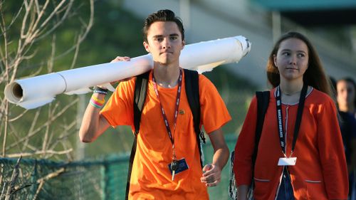 Marjory Stoneman Douglas student David Hogg walks to school with a large rolled banner over his shoulder on April 20, 2018 in Parkland, Florida. (AP)