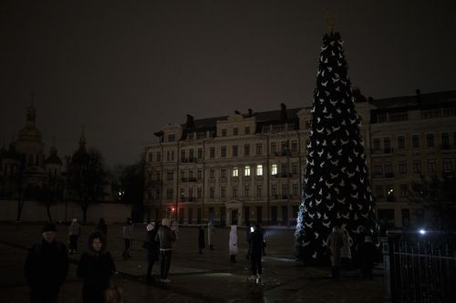 Українці фотографують новозбудовану ялинку на Софійській площі, оскільки в Києві тривають часткові відключення електроенергії, субота, 17 грудня 2022 року.  
