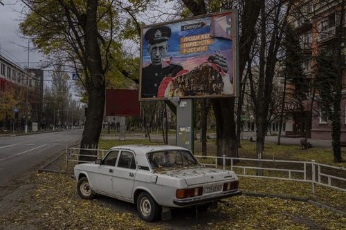 A partially torn-off Russian billboard in Kherson, southern Ukraine, Wednesday, Nov. 23, 2022. The text reads in Russian: "People of Kherson is proud of Russia". (AP Photo/Bernat Armangue)