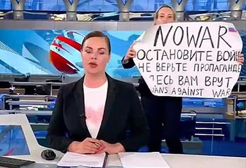 Marina Ovsyannikova holding protest sign behind Russian newsreader (supplied)