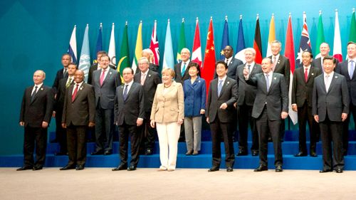 Putin was placed at the fringe of the group for the G20 family photo. (AAP)