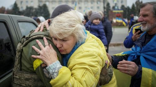 A local hugs a Ukrainian serviceman as people celebrate after Russia's retreat from Kherson city
