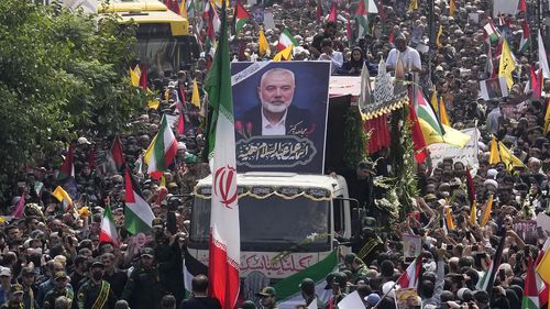 Gli iraniani seguono un camion, al centro, che trasporta le bare del leader di Hamas Ismail Haniyeh e della sua guardia del corpo, uccisi mercoledì in un omicidio attribuito a Israele, durante le loro cerimonie funebri in piazza Enghelab-e-Islami (Rivoluzione islamica) a Teheran, Iran, Giovedì 1 agosto 2024. (AP Photo/Vahid Salemi)