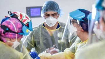 A team of doctors and nurses work on a COVID-19 patient in a Melbourne ICU ward.