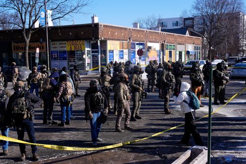 Federal agents stand near the site of a shooting Saturday, Jan. 24, 2026, in Minneapolis. (AP Photo/Abbie Parr)