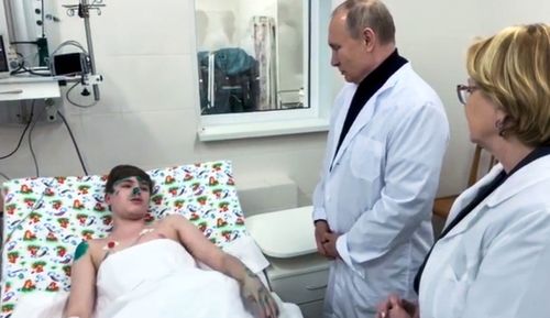 Russian President Vladimir Putin, second right, speaks to a boy wounded during collapsing of the apartment building in Magnitogorsk