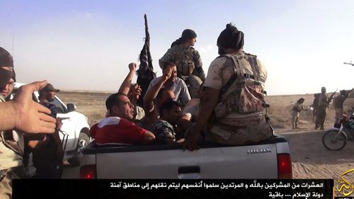 A photograph made available by the jihadist affiliated group Albaraka News allegedly shows ISIL fighters taking away Iraqi soldiers near the border between Syria and Iraq in 2014.