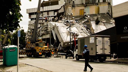 A policeman walks past a building destroyed by the 2011 Christchurch earthquake.