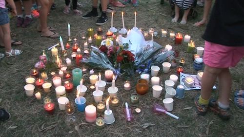 Candles are laid at a vigil for Zoe. (9NEWS)