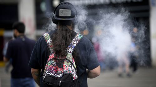 A man smokes a vape