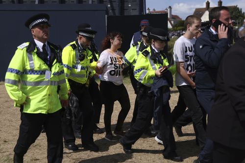 Just Stop Oil protesters are led away by police and security near the 17th hole during the second day of the British Open Golf Championships at the Royal Liverpool Golf Club in Hoylake, England, Friday, July 21, 2023.