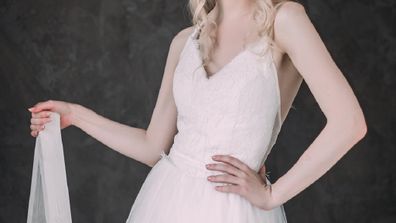 Portrait of a beautiful blond girl in image of the bride . Beauty face. Photo shot in the Studio on a grey background