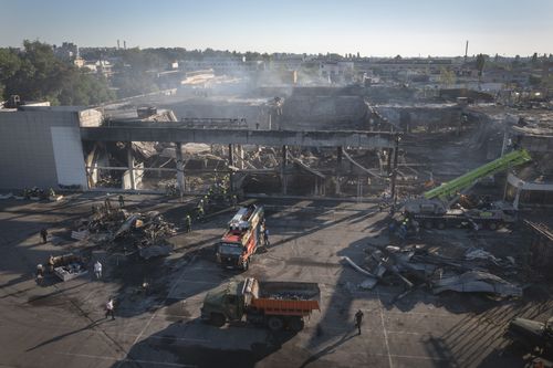 I vigili del fuoco del Servizio statale per le emergenze dell'Ucraina lavorano per rimuovere le macerie da un centro commerciale bruciato dopo un attacco missilistico a Kremenchug, in Ucraina, martedì.