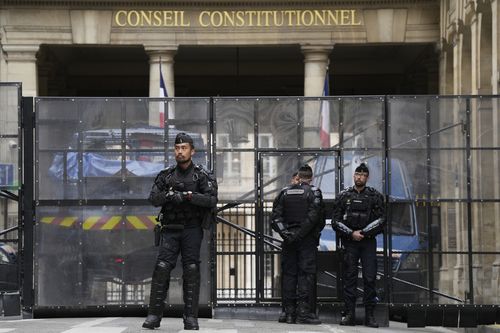 Police officers guard the entrance of the Constitutional Council Friday, April 14, 2023 in Paris.