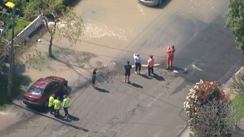 Shocked residents stand in their flooded street. (9NEWS)