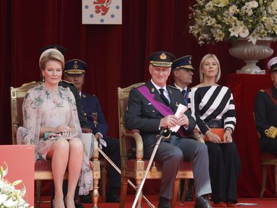 Belgium's Queen Mathilde, left, and Belgium's King Philippe, center, watch the National Day Parade from the podium in front of the Royal Palace in Brussels, Wednesday, July 21, 2021. Belgium celebrates its National Day on Wednesday in a scaled down version due to coronavirus, COVID-19 measures. (AP Photo/Olivier Matthys)