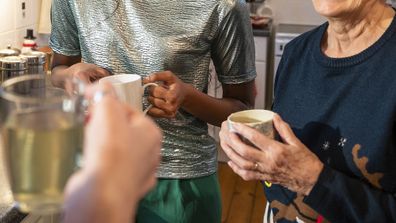 Shot of three-generation family enjoying a chat over a cup of tea in the kitchen at Christmas. They are in the North East of England.