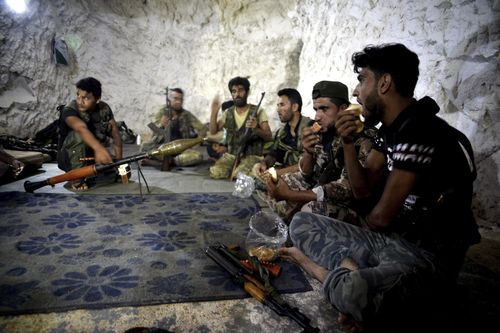 A motley crew of fighters with the Free Syrian army eat in a cave where they live, in the outskirts of the northern town of Jisr al-Shughur, Syria, west of the city of Idlib.