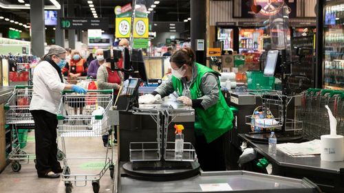 Une femme travaille au supermarché.