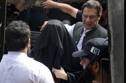 Pakistan's former Prime Minister Imran Khan, right, with his wife Bushra Bibi, centre, arrive to appear in a court in Lahore, Pakistan, on June 26, 2023.  