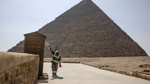 Municipal workers sanitize the areas surrounding the Giza pyramids complex in hopes of curbing the coronavirus outbreak in Egypt, Wednesday, March 25, 2020. 