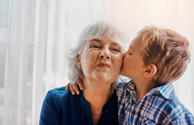 Young boy gives grandmother a kiss