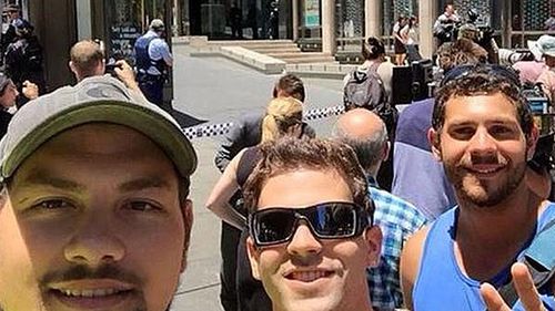 A group of friends took this selfie while standing behind police tape.