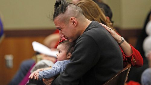Savanna LaFontaine-Greywind's boyfriend Ashston Matheny holds their daughter, Haisley Jo, as victim impact statements are read during the sentencing of Brooke Crews.