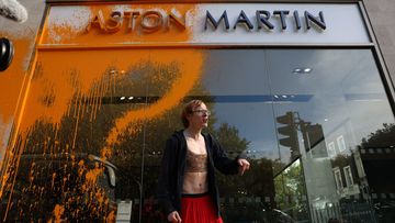 A demonstrator from Just Stop Oil sprays the Aston Martin Store in Mayfair 