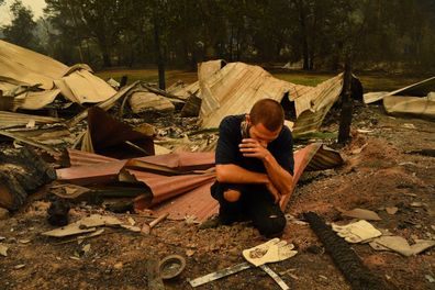 Karl Niehus unearths Water Dragon eggs from the ruins of his mother's business in Mogo's Main Street that was destroyed by the fire that swept through the town yesterday. Mogo, NSW. 1st January, 2020. 