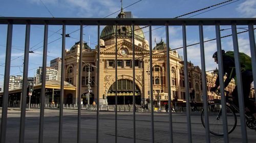 A cyclist passes an empty Flinders Street Station during lockdown due to the continuing spread of the coronavirus in Melbourne.