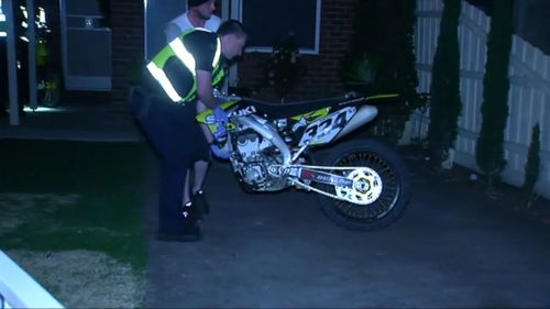 Officers seizing the motorbike.