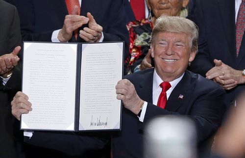 President Donald Trump holds up a signed proclamation to shrink the size of Bears Ears and Grand Staircase Escalante national monuments (AP Photo/Rick Bowmer)