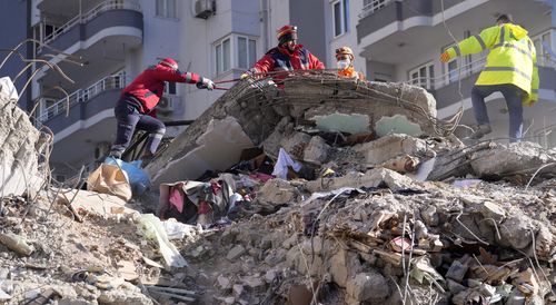 Emergency teams search for people in the rubble in a destroyed building in Adana, southern Turkey.