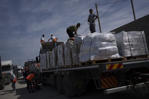 Trucks with humanitarian aid for the 'Gaza Strip enter from Egypt in Rafah on Saturday, Oct. 21, 2023.