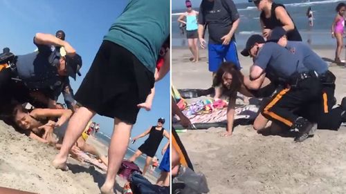 Police in the US have launched an investigation after video posted online shows an officer punching a woman on a beach in New Jersey.