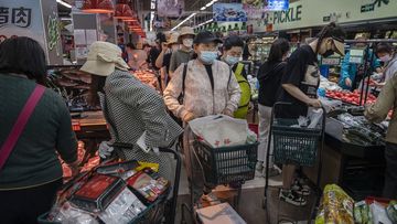 People crowd as they shop for food at a supermarket in Chaoyang District in Beijing, China